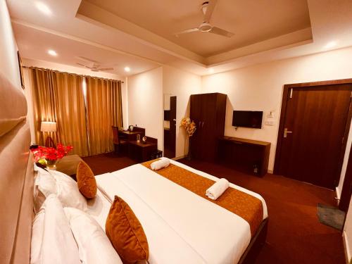 Habitación de hotel con cama grande y TV en Hotel Olive Vault, Most Awarded Property in Haridwar, en Haridwar