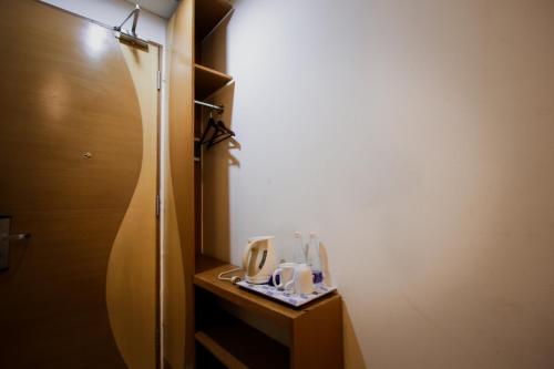 a small bathroom with a counter with cups on it at Serela Riau by KAGUM Hotels in Bandung