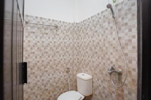 a bathroom with a toilet and a shower at RedDoorz Syariah near Jatisampurna Hospital in Bekasi