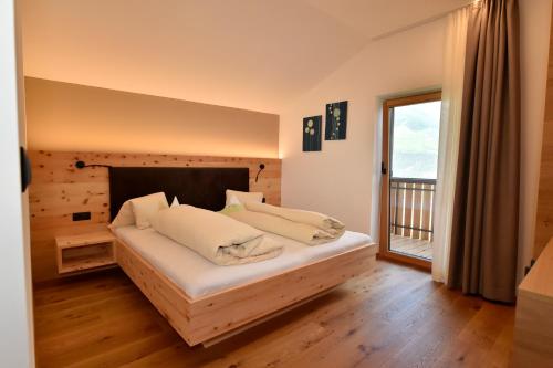 a bedroom with a bed and a window with a balcony at Sonnwarthof in Silandro