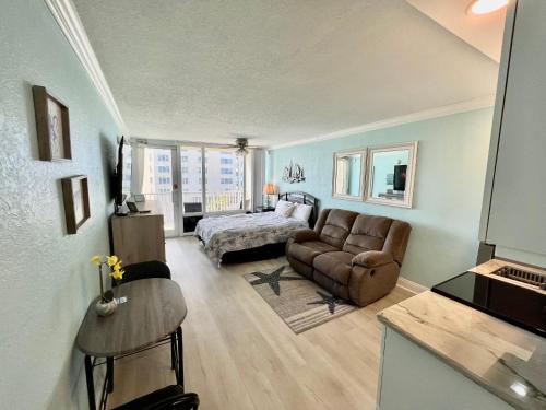 a living room with a bed and a couch at Pirates Cove 4th Floor Balcony Remodeled Condo in Daytona Beach