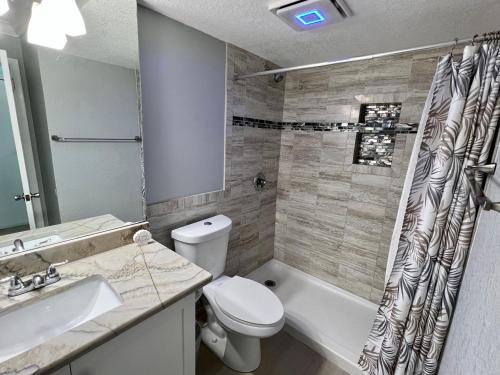 y baño con aseo, lavabo y ducha. en Pirates Cove 4th Floor Balcony Remodeled Condo, en Daytona Beach