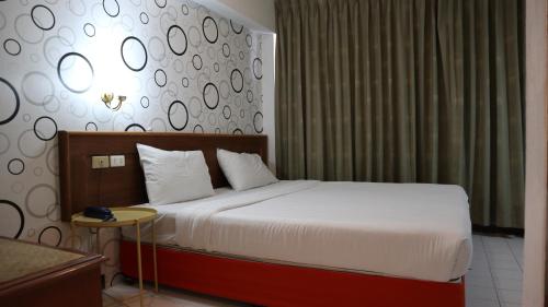 a hotel room with a bed and a table at Patong Triple P in Patong Beach