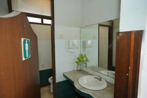 uma casa de banho com um lavatório e um espelho em Citere Resort Hotel em Pengalongan