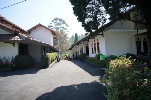 a driveway between two buildings with a motorcycle parked next to it at Citere Resort Hotel in Pengalengan