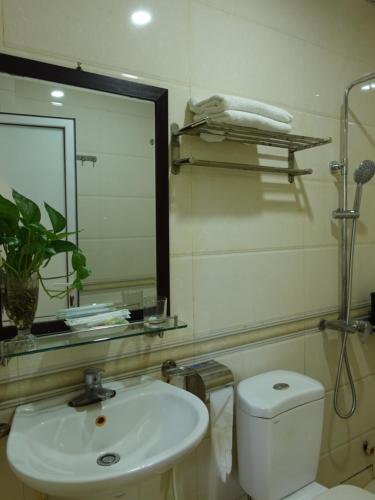 ein Badezimmer mit einem Waschbecken, einem WC und einem Spiegel in der Unterkunft Hoàng Lan - 22 Liền Kề 13, KDT Xa La - by Bay Hostel in Hanoi