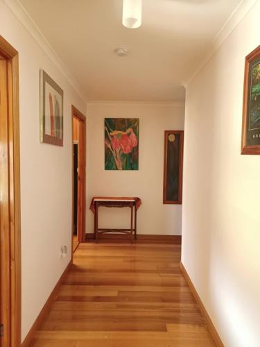 a hallway with white walls and a wooden floor at the tigers lair accomadation in Mole Creek