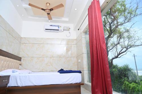 a bedroom with a bed and a window at Blue Pearl Beach Guest House in Māvalli