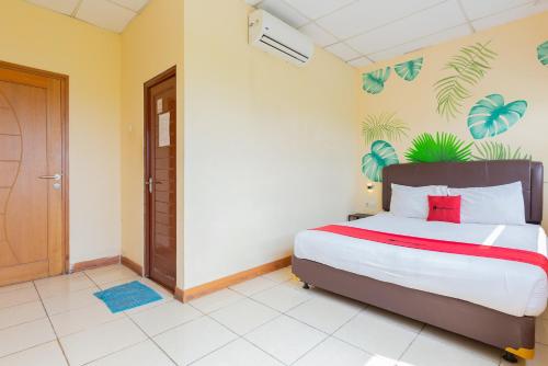 sypialnia z dużym łóżkiem i drzwiami w obiekcie RedDoorz @ Iodium Residence Cikarang w Dżakarcie