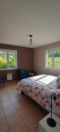 卡洛斯的住宿－Maison familiale au calme，一间卧室配有一张带花卉棉被和窗户的床。
