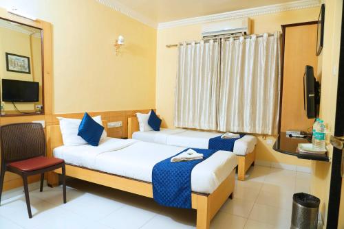 a hotel room with two beds and a television at hotel suraj classic in Pune