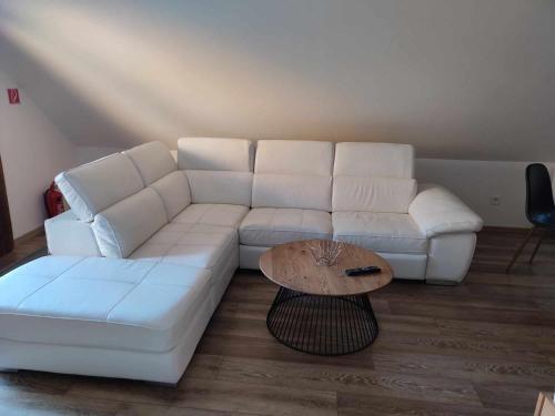 a living room with a white couch and a coffee table at Apartmán Tulipán in Hnúšťa
