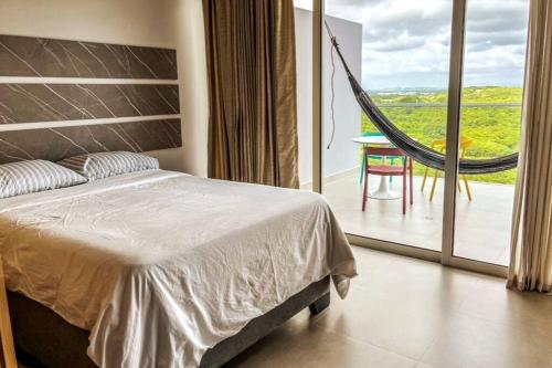 ein Schlafzimmer mit einem Bett und einer Hängematte auf dem Balkon in der Unterkunft Morros io Manzanillo, sensacional apartamento tipo Loft, salida directa a playa in La Siriaca