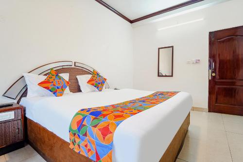 a bedroom with a bed with a colorful comforter at Hotel Orchid Inn in Ooty