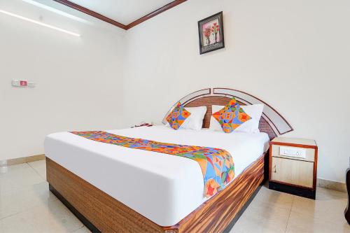 a bedroom with a large bed with a wooden headboard at Hotel Orchid Inn in Ooty