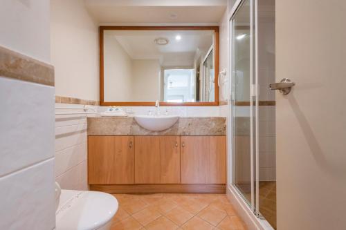 a bathroom with a sink and a mirror at Breakers 1 8 LJHooker Yamba in Yamba
