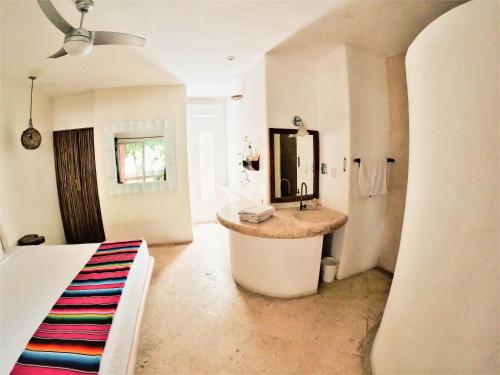 y baño con lavabo y espejo. en Rustik-inn Rooms en Playa del Carmen