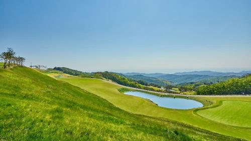 a golf course with a pond on a hill at Gyeongju Mauna Ocean Resort in Gyeongju