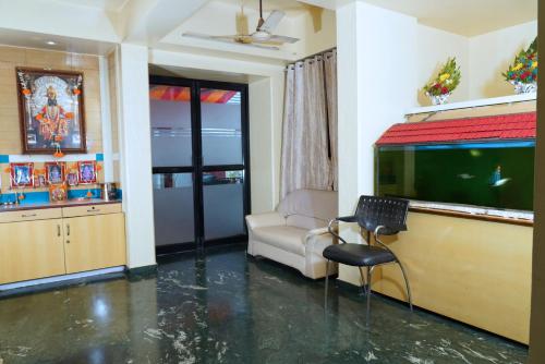 a living room with a fish tank and a couch at hotel suraj classic in Pune