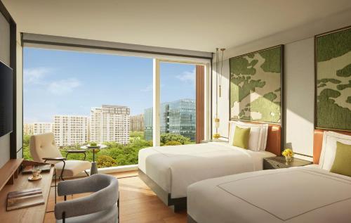 a hotel room with two beds and a large window at Taj The Trees, Mumbai in Mumbai