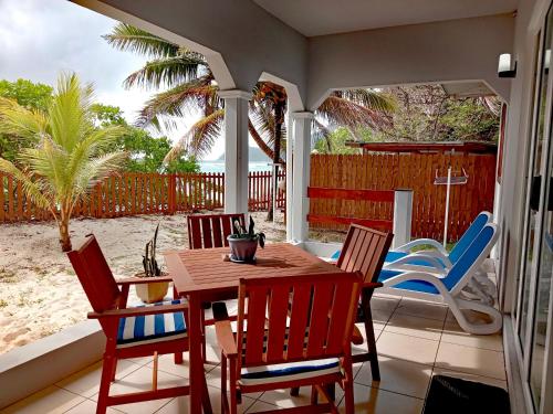 una mesa y sillas en un patio con playa en Roz A Mer - Beach Apartment en Mahe