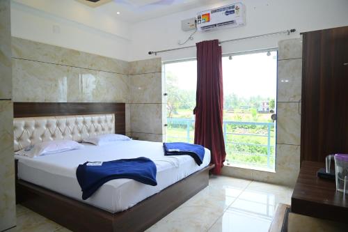 a bedroom with a large bed and a large window at Blue Pearl Beach Guest House in Māvalli