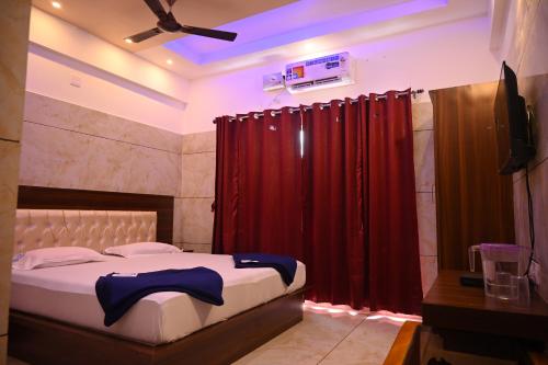 a bedroom with a bed with a red curtain at Blue Pearl Beach Guest House in Māvalli