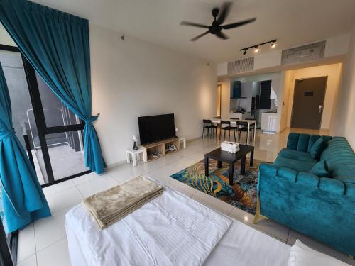 a living room with a blue couch and a tv at Beacon Executive Suites in George Town