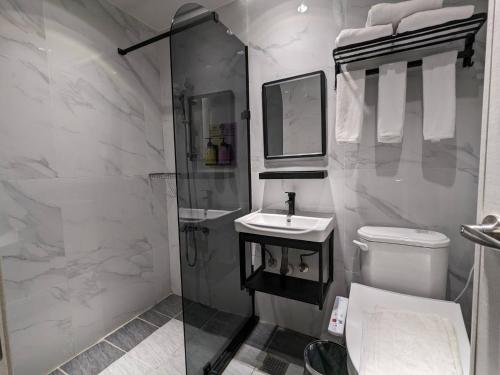 a white bathroom with a sink and a toilet at 亞馨文旅 近東大門夜市 有免費停車場 可自助入住 in Hualien City