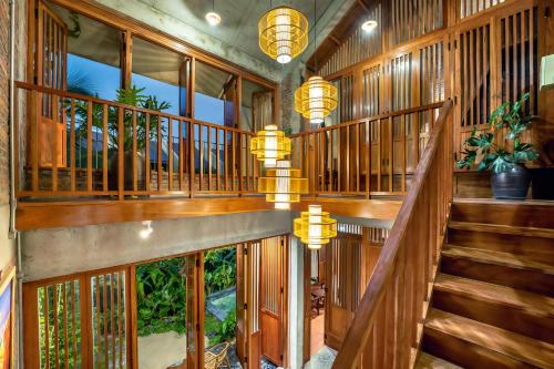 a staircase in a house with wooden walls and lights at Faifo Retreat Villa Hội An in An Bang