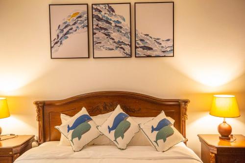 a bedroom with a bed with four paintings on the wall at Phuket Boutique Pool Villa-81 in Rawai Beach