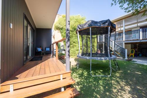 a porch with a swing on the side of a house at Cozy 1 Bed 1 Bath Tiny Home near CBD in Brisbane