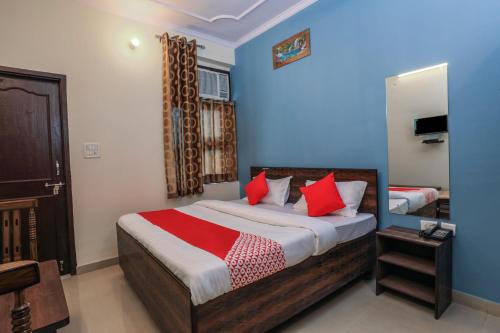 een slaapkamer met een bed met rode kussens bij OYO New Airport Residency in Jaipur