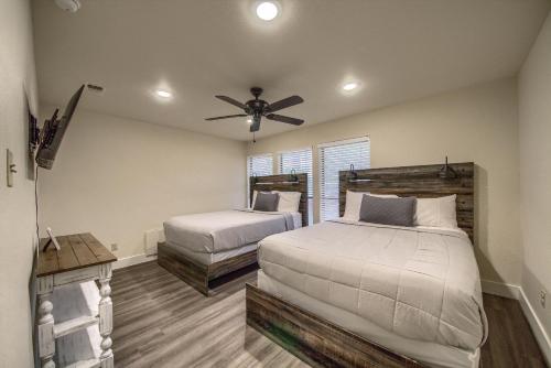 1 dormitorio con 2 camas y ventilador de techo en CW CH Camp Warnecke Club Haus, en New Braunfels