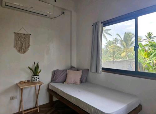 Zimmer mit einer Bank, einem Fenster und einem Tisch in der Unterkunft Pacifico Surf Bayay 