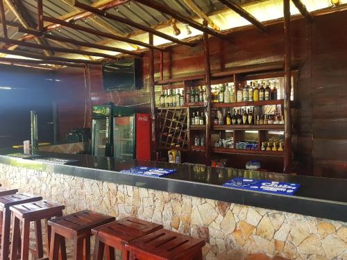 un bar con taburetes de madera y botellas de alcohol en C and G Resort hotel Hoima, en Hoima