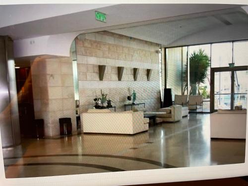 a lobby of a building with a couch and a table at Luxury apartment on the beach in Herzelia 