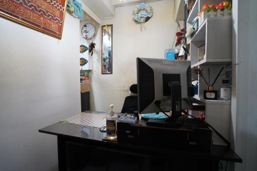 a desk with a computer on top of it at OYO Life 93023 Kost Bulan Karawang in Karawang