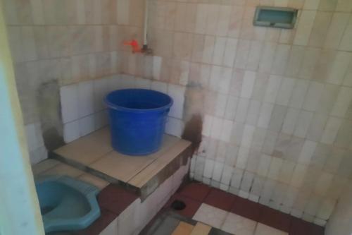 a small bathroom with a blue bucket in it at OYO Life 93023 Kost Bulan Karawang in Karawang