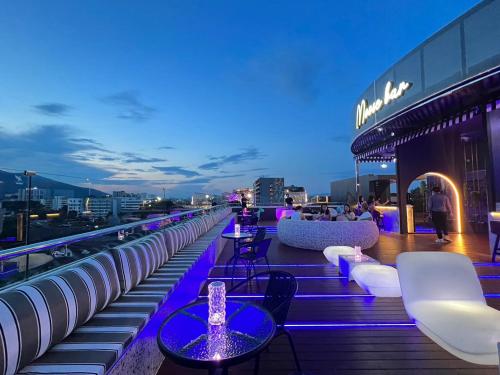 a rooftop bar with tables and chairs on a building at Moose Hotel Nimman in Chiang Mai