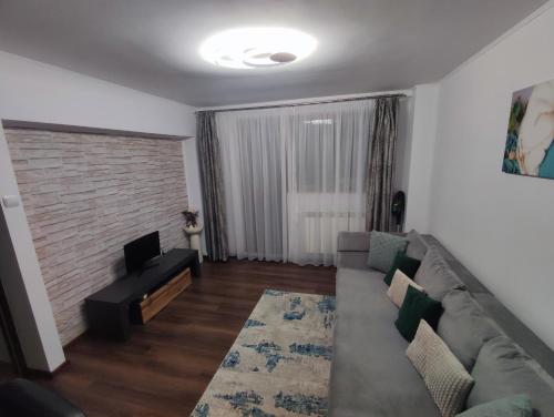 ein Wohnzimmer mit einem Sofa und einem TV in der Unterkunft Apartament Belvedere in Galaţi