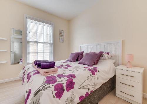 a bedroom with a large bed with purple pillows at Butchers Loft in Saundersfoot