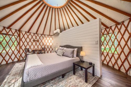 a bedroom in a yurt with a bed and a table at OT 3515B Texas Yurt Haus Buffalo in New Braunfels