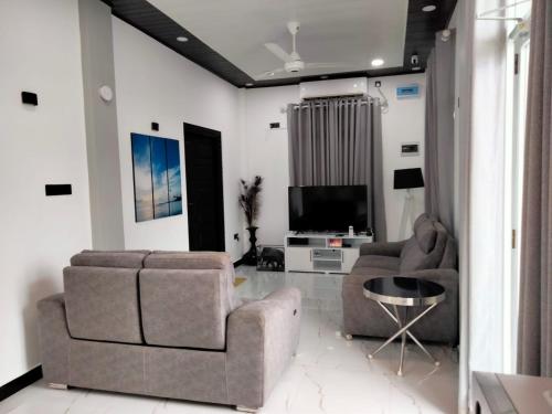 a living room with two chairs and a television at Florence Villas in Jaffna