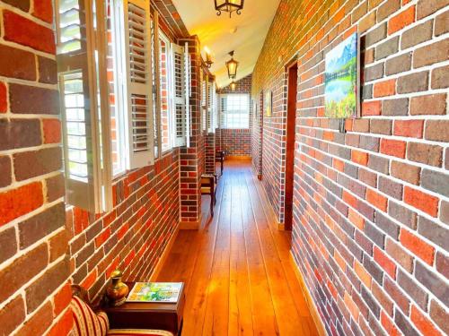 an empty hallway with a brick wall and a table at 墾丁勿忘我城堡莊園 in Hengchun