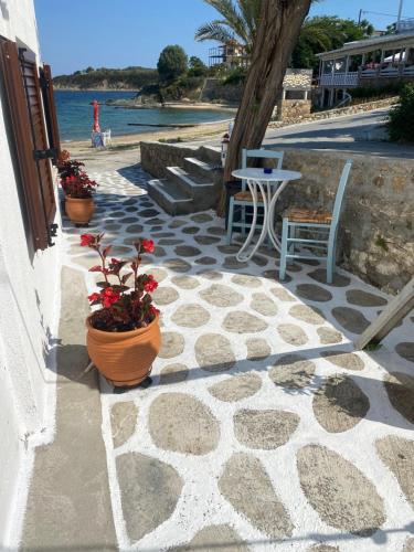 a patio with two chairs and a table and flowers at IRENE traditional apartments in Ammouliani