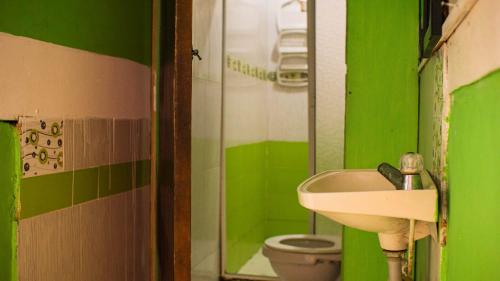 een groene badkamer met een wastafel en een toilet bij Cabañas con vista al mar Playa Juanchaco in Buenaventura