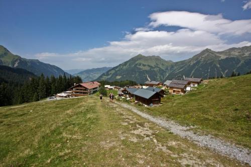 a group of people walking down a grassy hill at T3 Alpenhotel Garfrescha in Sankt Gallenkirch