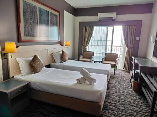 a hotel room with two beds and a television at Seaview Deluxe Rainbow Paradise Tg Bungah 6pax in Tanjung Bungah