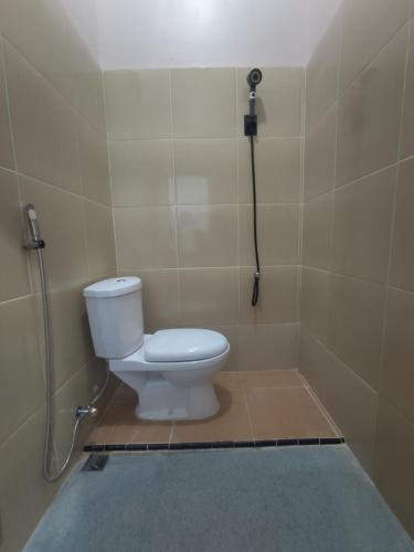 a bathroom with a toilet in a shower stall at Home Syariah Guest House Ampana in Dondo